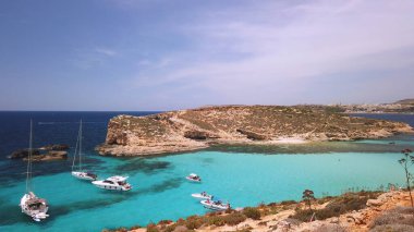 Comino, Malta 29.05.2024 - Blue lagoon yakınlarında demirli tekneler, Cominotto adasının arkasında. Atış serbest. Yüksek kalite fotoğraf