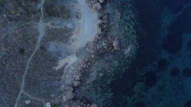 Tat-Tonn or Spritzing rock, snorkeling point between Qarraba Bay and TaBabu Cove, Ghajn Tuffieha, Mgar, Malta. Aerial view of the emerald sea and rocky coast in early morning still in the shade of clipart