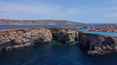 Cominotto, Malta, Comino yakınlarındaki ıssız adanın deniz mağaralarının havadan görünüşü. Çerçevede uçan martı. Yüksek kalite fotoğraf