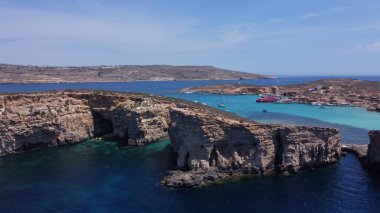 Cominotto, Malta, Comino yakınlarındaki ıssız adanın deniz mağaralarının havadan görünüşü. Çerçevede uçan martı. Yüksek kalite fotoğraf