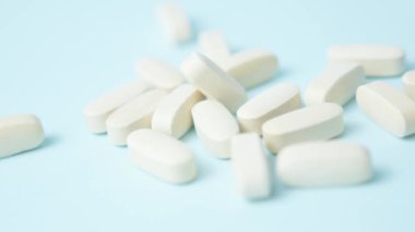 Açık mavi arka grund üzerine beyaz haplar, hafif odaklanma, makro. Yüksek kalite 4k görüntü