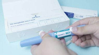 Qawra, Malta, 26.10.2024 - Semaglutide, Ozempic kalem. Kadın enjektör kalemini açıyor. Yumuşak odaklanın. Yüksek kalite 4k görüntü