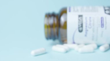 Qawra, Malta, 26.10.2024 Magnezyum sitrat kavanozu ve bir sürü beyaz kapsül hapları. Raflara odaklan. Yüksek kalite 4k görüntü