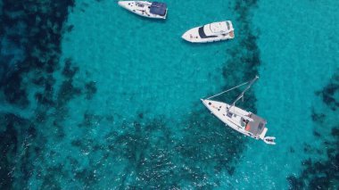 Kristal berrak turkuaz deniz suyunda yüzen tekneler. Mavi Göl, Comino, Malta Adaları. Havadan yüksek açı görüntüsü. Yüksek kalite fotoğraf