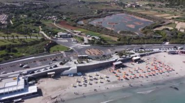 Malta Havalimanı, Kasım ayında şemsiyeli beyaz kumlu plaj. Ghadira Doğa Koruma Alanı yakınlarındaki kavşağa yaklaşıyoruz. Yüksek kalite 4k görüntü