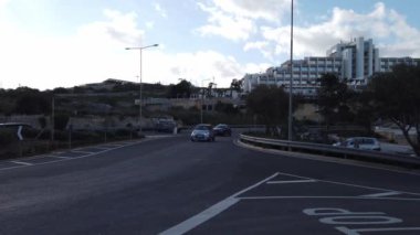 Salini, Malta 22.11.2024 Saini tatil köyünün önündeki kavşağın yakınında trafik var. - Evet. Yüksek kalite 4k görüntü
