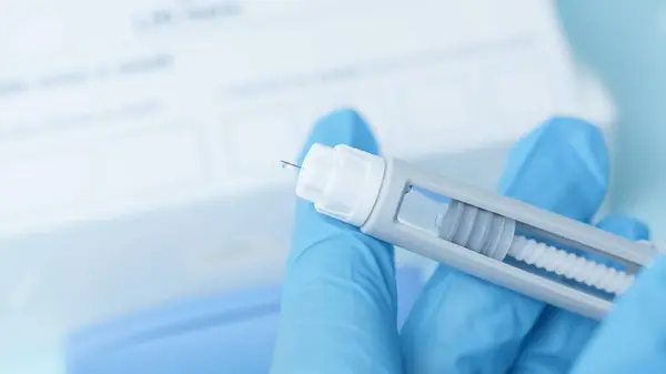 Diyabetik ilaç kaleminin iğnesini kapat. Mavi parlayan kalemli eller. Yüksek kalite fotoğraf