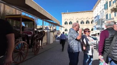 Valletta, Malta 25.11.2024 - Barrakka bahçeleri, Valletta Malta. Gorg Borg Anıtı 'na doğru ağır çekimde yürü. Yüksek kalite 4k görüntü