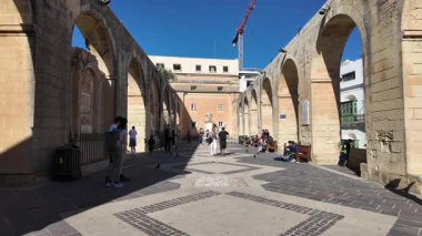 Valletta, Malta 25.11.2024 - Yukarı Barrakka bahçelerinde kuşlar ve insanlar, Maltalı doktor ve filozof Joseph Nicholas Zammit 'e yaklaşıyorlar, aslan heykeli, Yukarı Barracca Bahçesi, Valletta