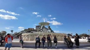 Valletta, Malta - 25.11.2024 - Malta Valletta, Malta 'da Heykeltıraş Vincent Apap tarafından Triton Çeşmesi' nin etrafında hiperlapa. Muhabbet eden insanlar. Yüksek kalite 4k görüntü