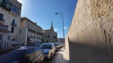 Valletta, Malta - 25.11.2024 - Hyperlapse Valletta, St Paul Katedrali 'nin çan kulesine doğru yürü. Yüksek kalite 4k görüntü