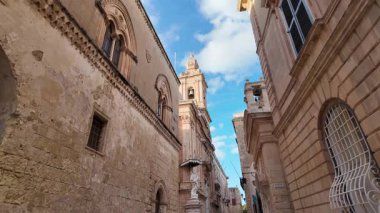 Mdina, Malta 23.11.2024 - Kilisenin dar sokakları ve çan kulesi Saint Paul Metropolitan Katedrali, yaygın olarak St Pauls Katedrali veya Mdina Katedrali olarak bilinir. Yüksek kalite 4k görüntü