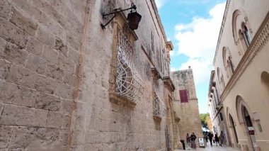 Mdina, Malta 23.11.2024 - Mdina 'nın dar sokaklarını keşfeden turistler. Yüksek kalite 4k görüntü
