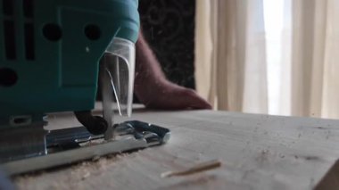 Yeşil bir yapboz, parlak bir tahtayı testereyle keser, yavaş çekimde kapatır. Yüksek kalite 4k görüntü