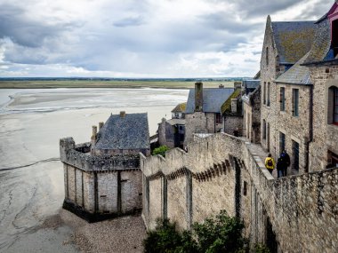 Normandiya, Fransa, 22 Eylül 2023 Mont Saint-Michel 'in perde duvarlarından birinde yürüyen bazı insanların görüntüsü.