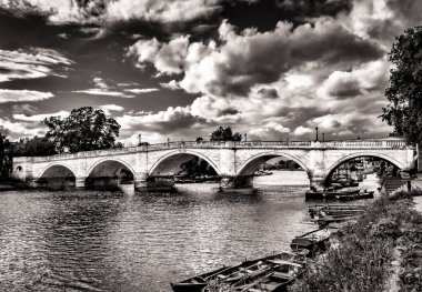 Richmond Köprüsü 'nün Thames Nehri' nin üzerinden geçtiği ve yazın Londra, İngiltere 'de bulutlu bir günde kayıkla gezdiği