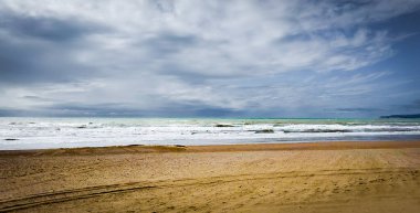 Camber Sands Plajı manzarası, İngiltere 'nin doğu Sussex sahilinde bulutlu bir günde kumlu bir sahil.