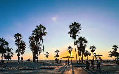 Kaliforniya, ABD, 1 Ekim 2024, Ocean Front Walk, Venice Beach 'te gün batımında insan manzarası