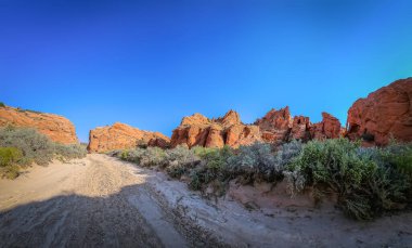 Edmaier 'in gizli yolu Utah' taki çöl toprak yolu ve kaya oluşumunun görüntüsü.