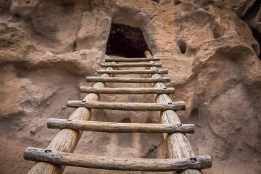 Wooden ladder leading to a cavate in Bandelier National Monument on the Pueblo Loop Trail occupied by the Ancestral Puebloans, few hundred years ago  clipart