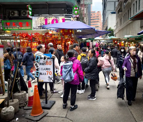 Hong Kong, Hong Kong Adası, 29 Ocak 2024, Wan Chai bölgesindeki Tai Yuen Caddesi 'ndeki bir sokak pazarındaki şehir manzarası.