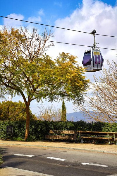 Barcelona Spain. Ropeway with cabin at mountain Monjuic. Picturesque cityscape with blue sky.