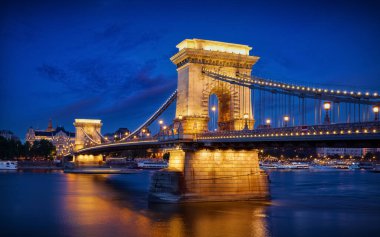 Budapeşte, Macaristan. Budapeşte 'de Tuna nehri üzerinde gece lambaları ve mavi gökyüzü için fenerlerle zincirli köprü. Akşam saati.