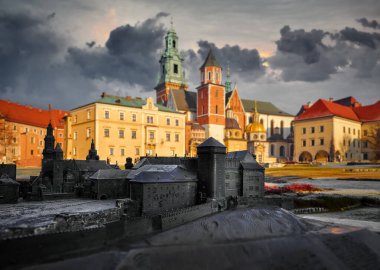 Polonya, Krakow 'daki Wawel Kalesi. Eski kale kuleleri ve Katolik tapınağı. Resimli bir sonbahar günü, akşam sıcacık güneş ışığıyla. Gökyüzü dramatik bulutlar