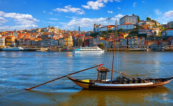 葡萄牙波尔图古城 阳光灿烂的日子笼罩在沿河天际线的房顶上 独木河上的古船 装有港湾酒桶 — 图库照片