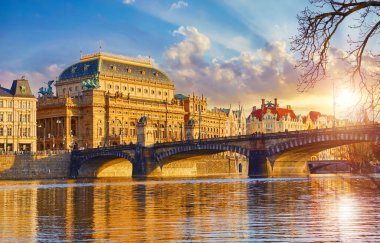 Prag, Çek Cumhuriyeti. Vltava nehri üzerindeki Legion Köprüsü 'ne bakın. Ulusal Tiyatro (Narodni Divadlo) gün batımında gün batımının ışıltılarıyla doludur.