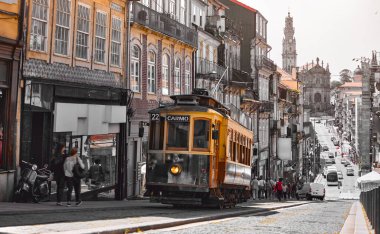 Porto, Portekiz. Raylardaki antika tramvay. Tramvay yolu ile toplu taşıma. Gün batımında popüler turistik porto sokağı.