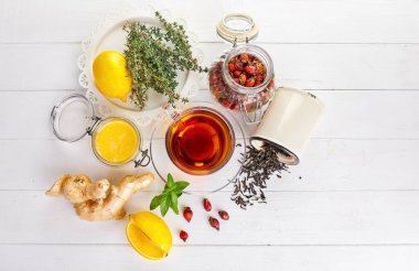 Limonlu zencefilli çay, tatlım, beyaz ahşap tahtada Rose Hip ve kekik. Üst görünüm.