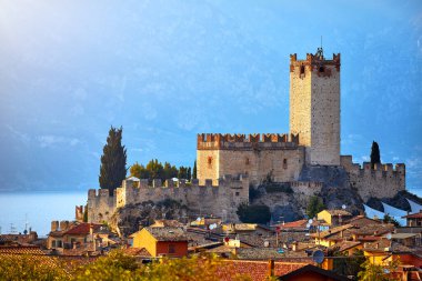 İtalya 'nın Veneto bölgesindeki Garda Gölü' ndeki Malcesine antik kulesi ve kalesi. Çatıları olan yaz manzaralı bir ev..