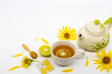 Bitkisel sağlıklı içecekler sıcak bal limonu ve sağlık hizmetleri için pastil. Boğazım ağrıyor. Çiçeklerle ayçiçeği aranjmanı düzleştiriliyor.