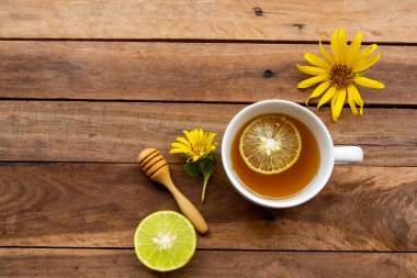 Sağlıklı bitkisel içecekler sağlık hizmetleri için sıcak bal limonu Çiçeklerle boğaz ağrısı Ayçiçeği düzenleme düz arka plan ahşap üzerinde yatıyordu