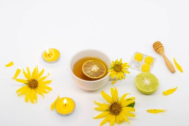 Bitkisel sağlıklı içecekler sıcak bal limonu ve sağlık hizmetleri için pastil. Boğazım ağrıyor. Çiçeklerle ayçiçeği aranjmanı düzleştiriliyor.