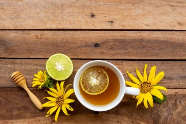 Sağlıklı bitkisel içecekler sağlık hizmetleri için sıcak bal limonu Çiçeklerle boğaz ağrısı Ayçiçeği düzenleme düz arka plan ahşap üzerinde yatıyordu