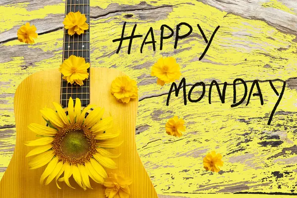 happy monday message card handwriting with yellow flower and guitar arrangement flat lay postcard style on background yellow wooden