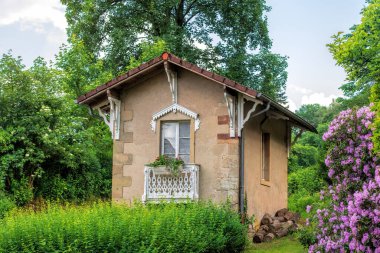 Ağaçlı bir bahçede küçük bir ev
