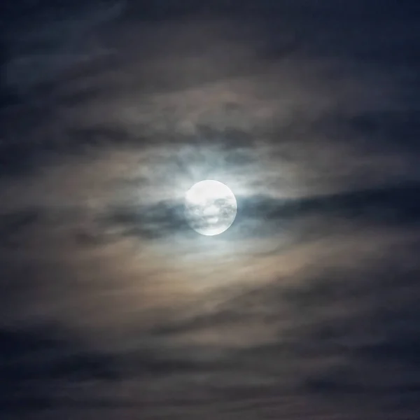 full moon behind clouds