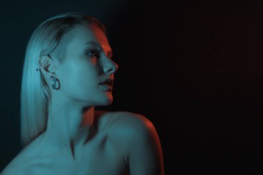 Fashion woman portrait on dark background with soft blue and red lights play on skin and copy space.