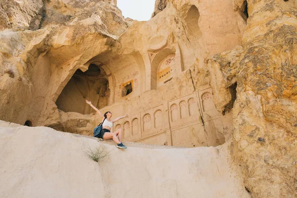 Duvarları Kemerleri Oyulmuş Bir Mağaranın Önündeki Kayanın Üzerinde Oturan Genç Stok Resim