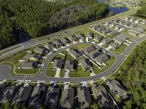 森林边的柏油路是典型的美国住宅开发的空中景观 图库图片