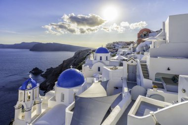 Yunanistan 'ın Santorini Adası' ndaki dik kayalıklarda beyaz mağara evleri ve mavi kubbe kiliseleri