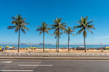 Rio de Janeiro, Brezilya 'da Ipanema Sahili' nde Palm Trees ile güneşli bir gün. Sahilin önündeki ünlü mozaik kaldırım.