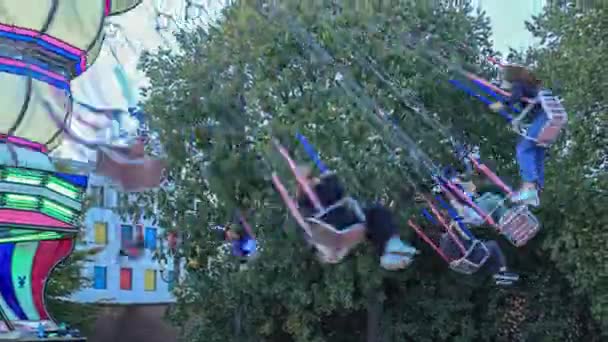 석양에 놀이공원에서 비행기 파크의 날아다니는 비행기를 청소년들 — 비디오