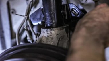 Araba süspansiyonunun bakımı sırasında tamirci elleri detayı