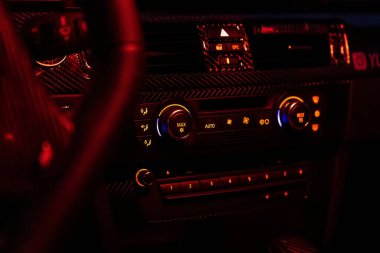 Arabanın gösterge paneli, koyu renk havalandırma kontrol paneli. Modern bir arabadaki kontrol paneli araba kliması veya konsol teknolojisi. Sürücü el ayarı, havalandırma ızgarası, temiz hava geliyor..