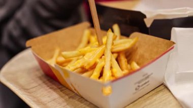 Fast food kızartması toplayıp domates ketçapına batıran eller. Kızarmış patates cipsi 4K yakın plan.