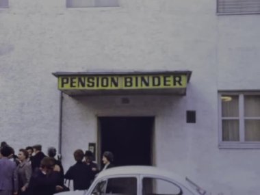 Molveno, İtalya Mart 1973: 70 'lerdeki konuk evi sahnesi önünde bir grup turist